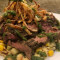 Steak Over Chayote Corn Hash, Fried Onions, Zhoug Sauce (1)